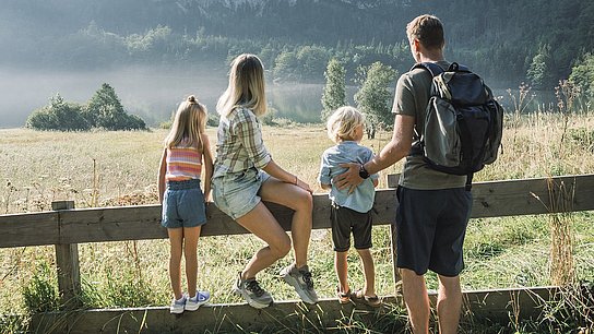 Familie am Holzzaun beim Laudachsee