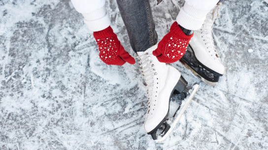 Eislauf-Schuhe mit roten Wollhandschuhen