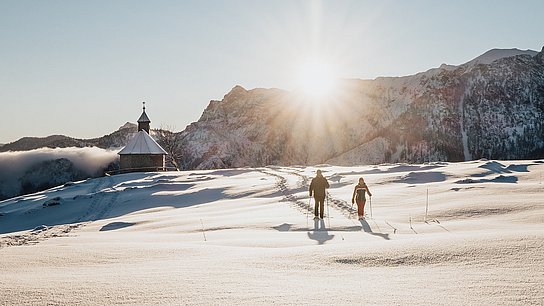 Schneeschuhwanderung bei Sonnenaufgang an der Postalm-Kapelle