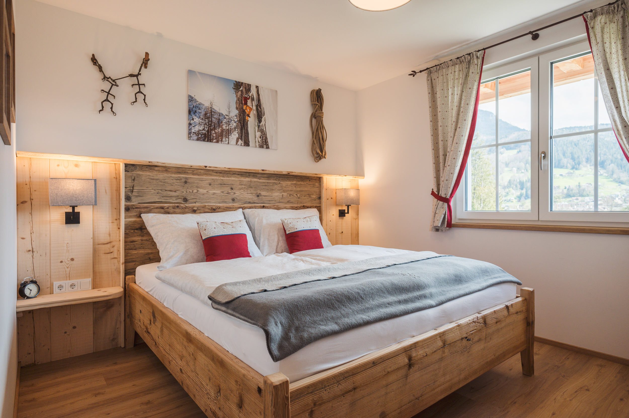 Schlafzimmer 1 mit Altholzbett, Bergsteiger-Foto und Steigeisen-Deko