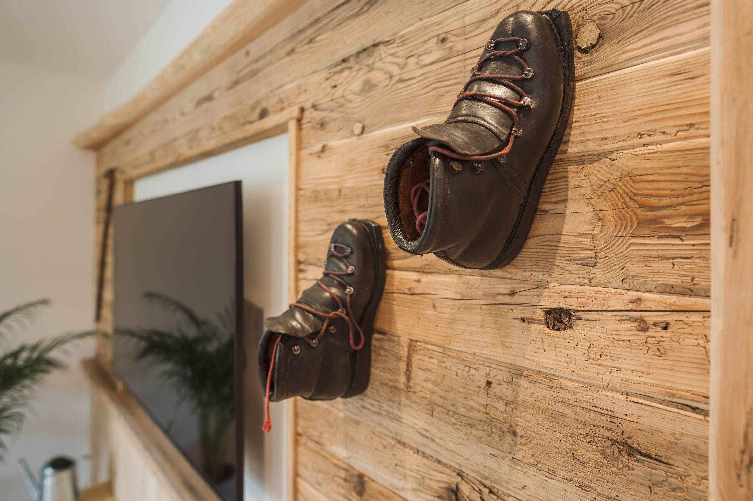 Detail: antike Bergschuhe als Wand-Deko über dem Smart-TV