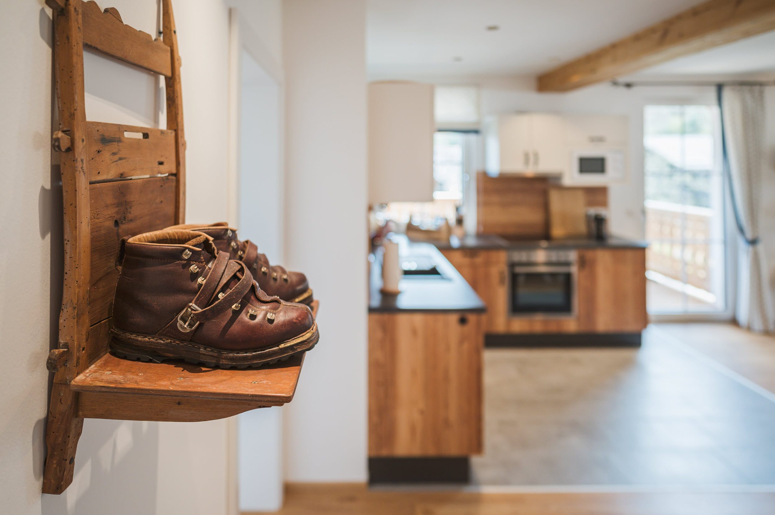Bergfex-Wohnung: antike Bergschuhe als Wand-Deko, Blick in die Küche