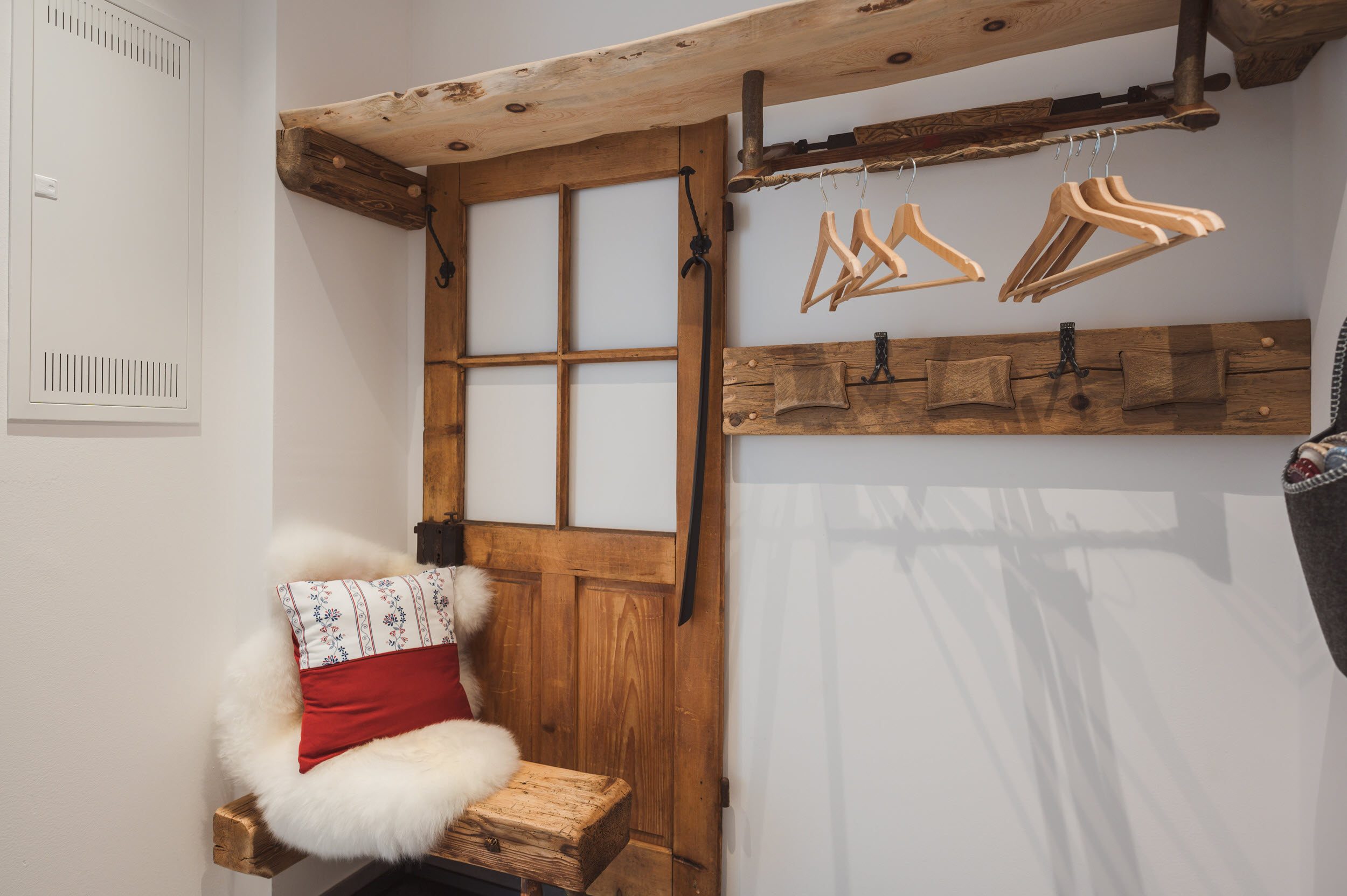 Garderobe mit altem Schlitten, Holztür und Schaffell