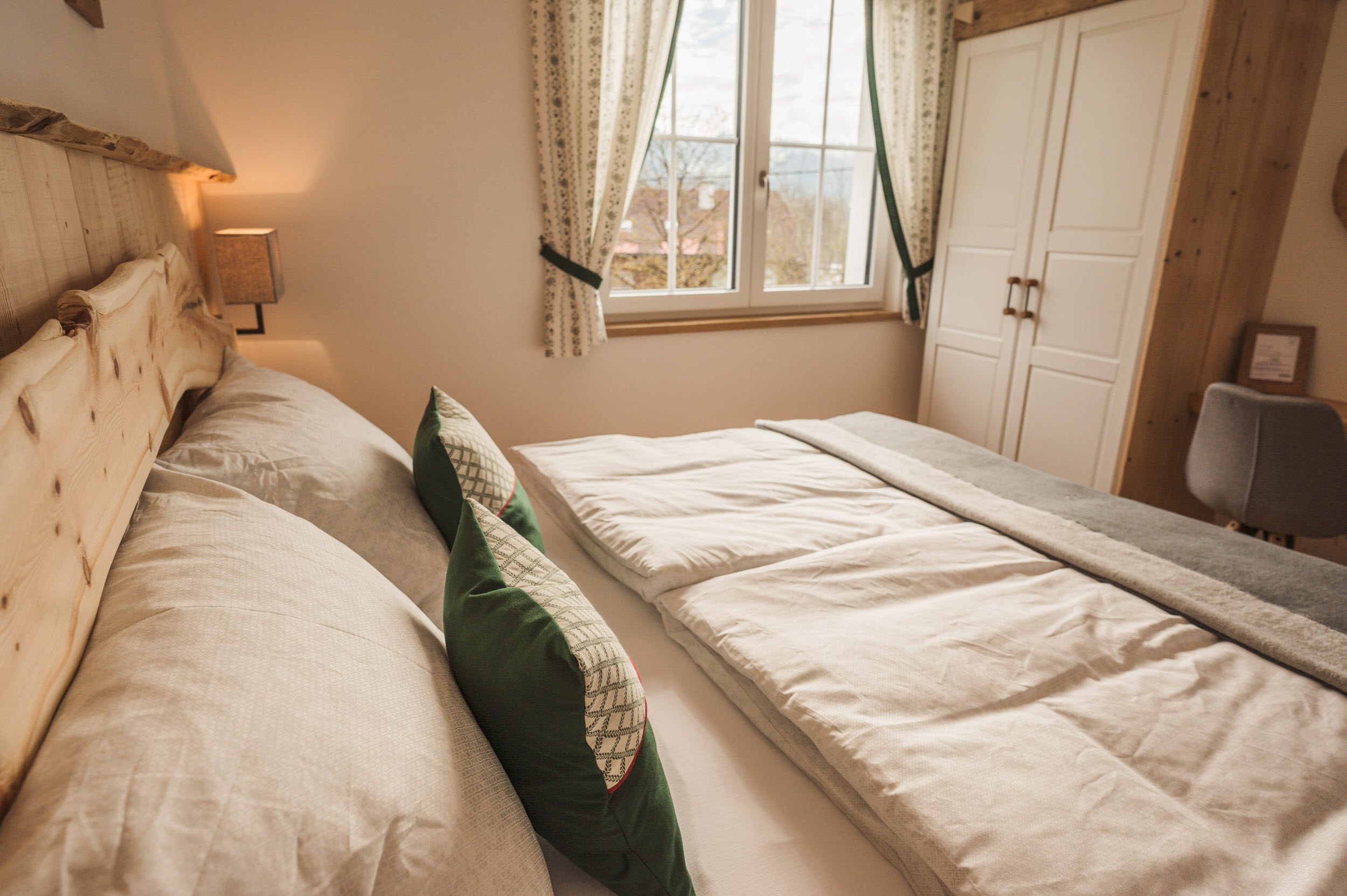 Schlafzimmer-Seite mit weißem Schrank und Zirbenbett