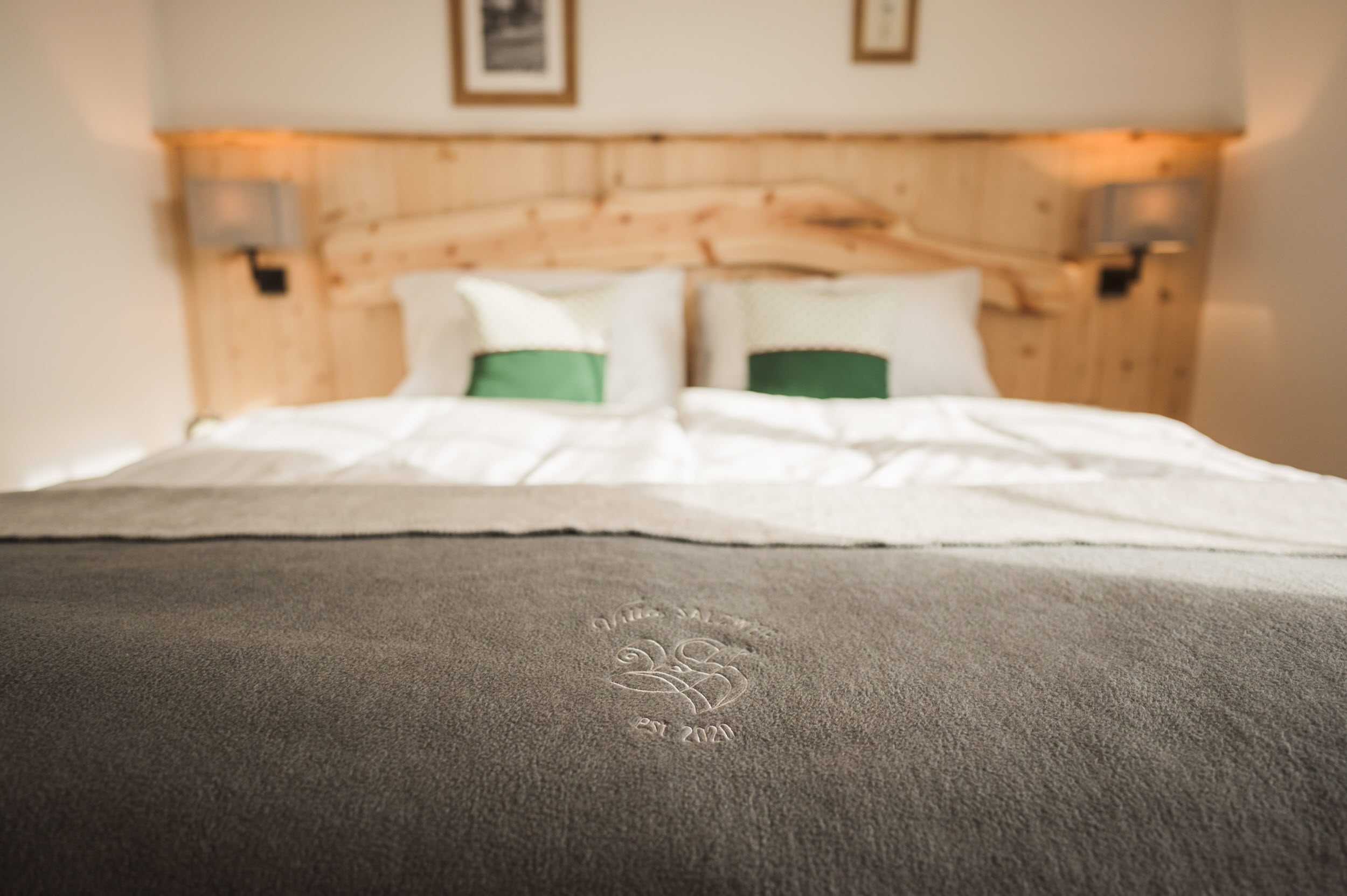 Bett-Detail mit Villa-Salzweg-Decke und Zirbenholz-Kopfteil