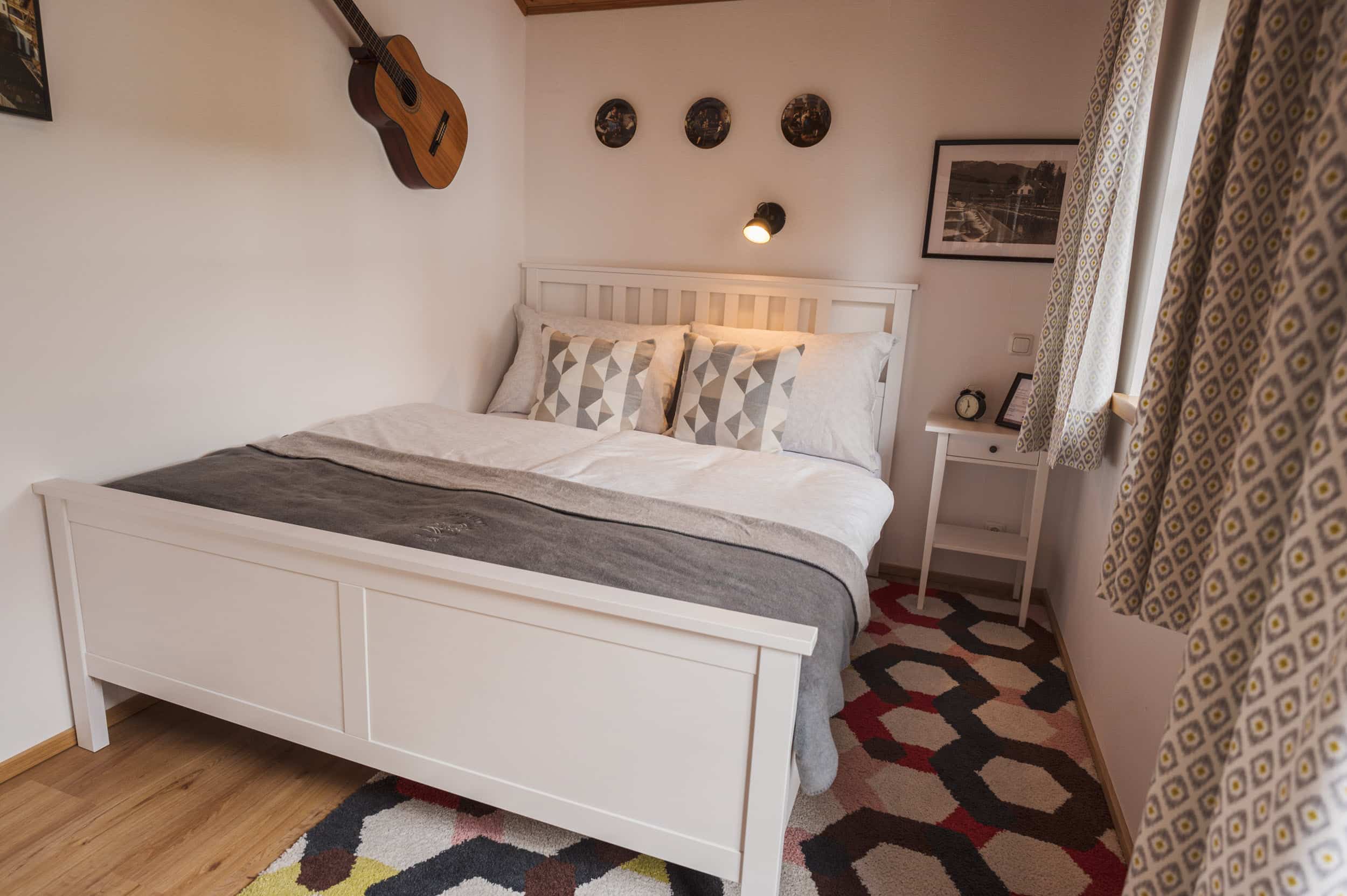 Musiker-Wohnung: zweites Schlafzimmer mit Gitarre über dem Bett