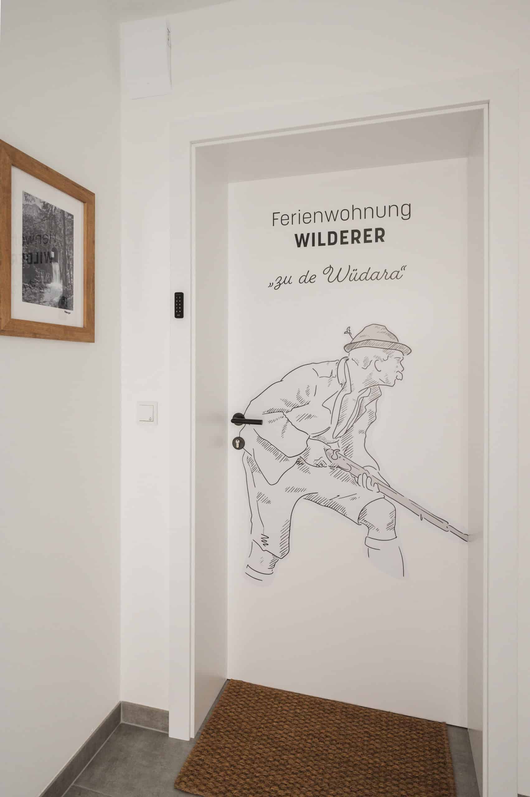 Eingangstür der Wilderer-Wohnung mit gezeichnetem Wildschütz