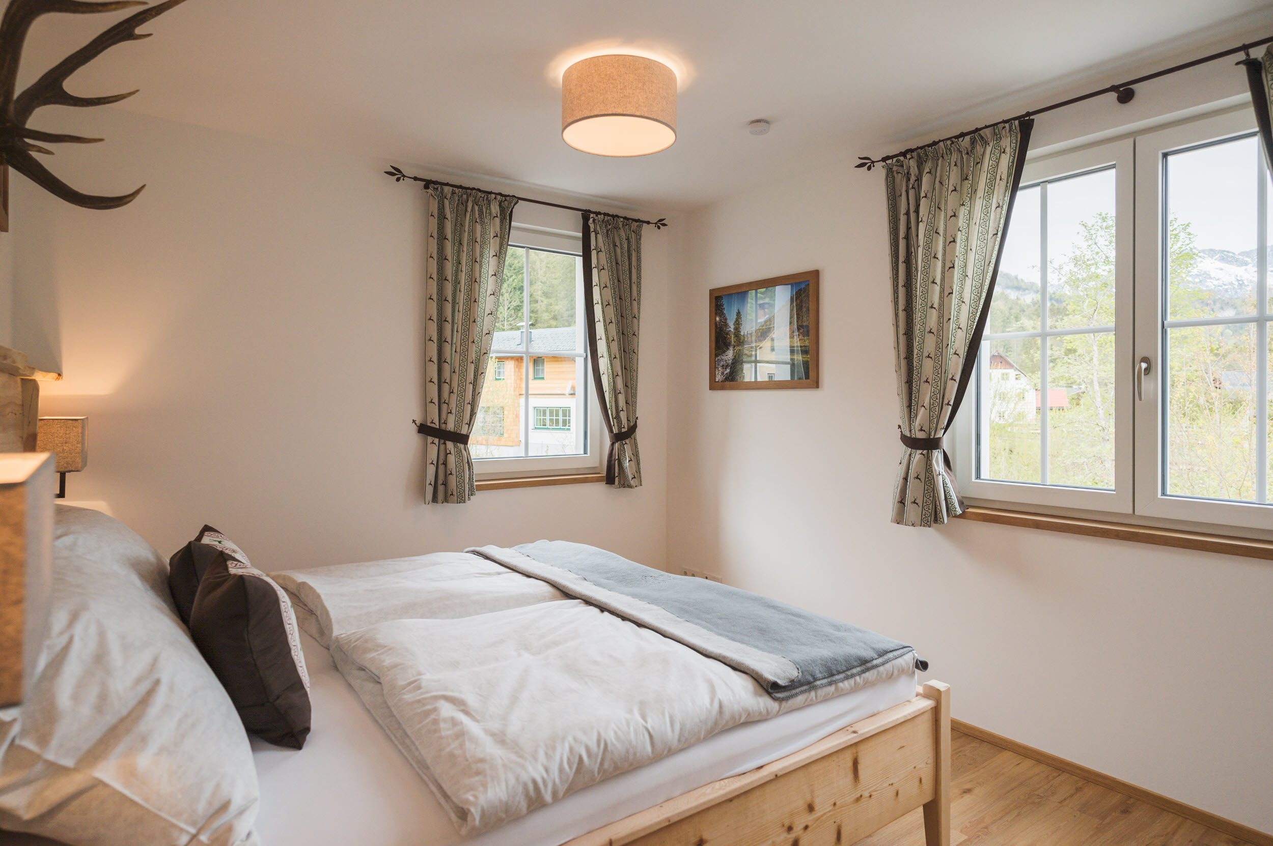 Schlafzimmer 1 von der Seite mit Bergblick durchs Fenster