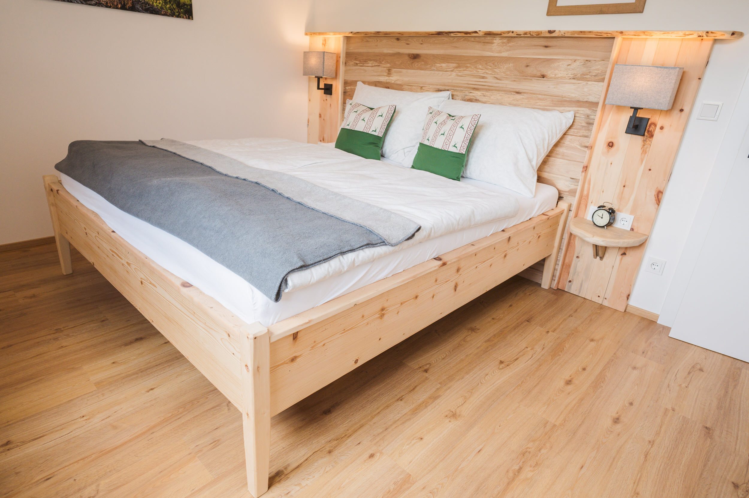 Schlafzimmer 2 mit Bett, grünen Hirschkissen und Nachttischlampen